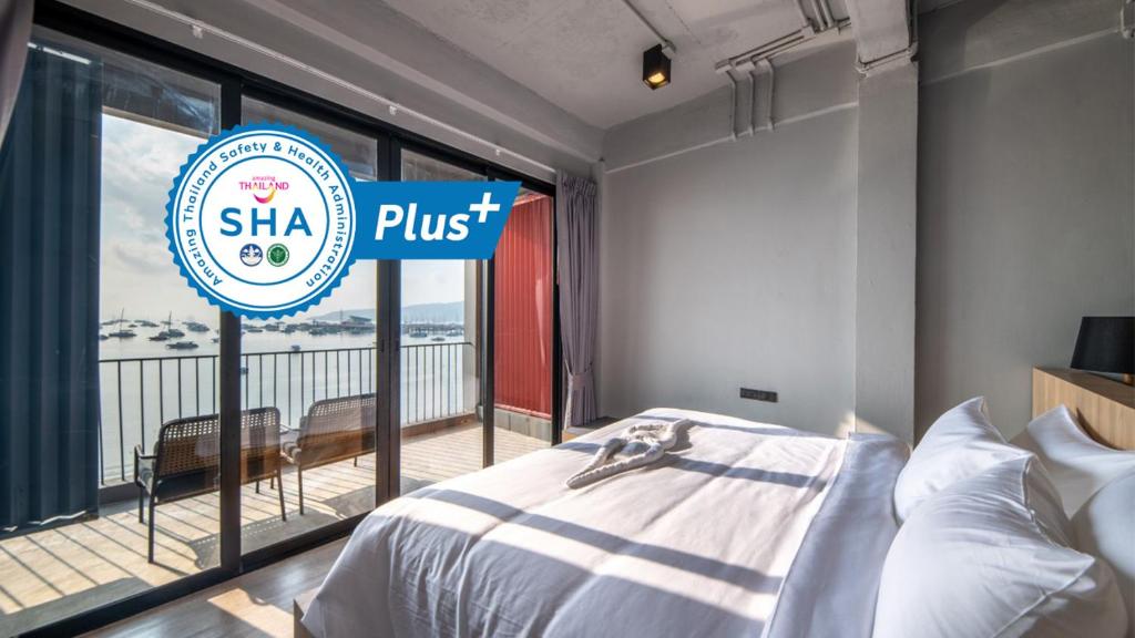 a bedroom with a bed and a sign that reads shka plus at Arch39 Phuket Beach Front - SHA Plus in Chalong 