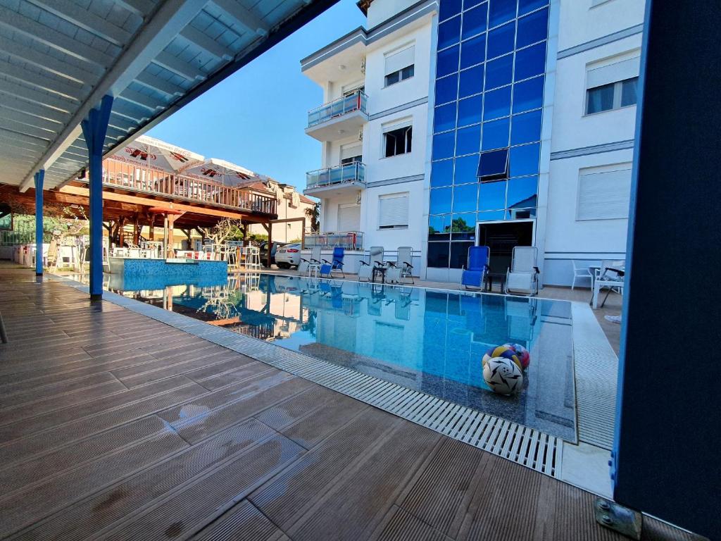una persona tumbada en una piscina junto a un edificio en Brian Hotel, en Velipojë