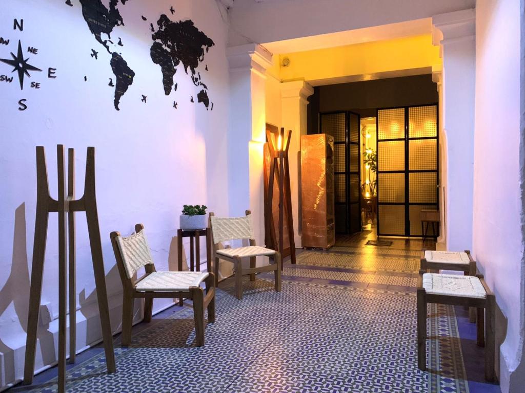 ein Zimmer mit Stühlen und einer Karte an der Wand in der Unterkunft Casa Mazonce in Mexiko-Stadt