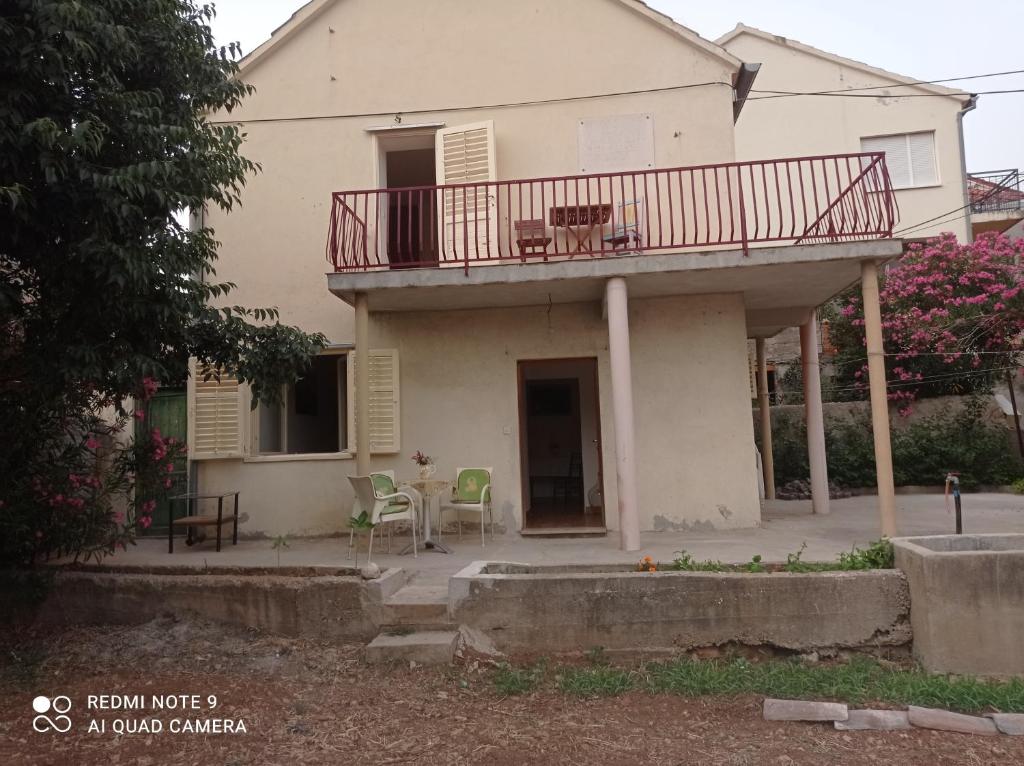 a house with a balcony with a table and chairs at Kuća za odmor Ljubica Šibenik in Šibenik