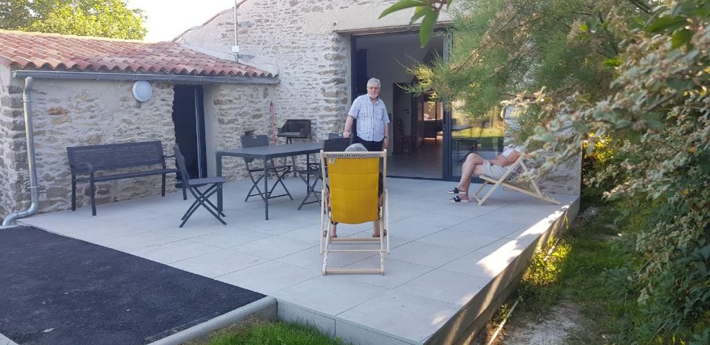 a man standing on a patio in front of a house at Chez Marcel in La Marne