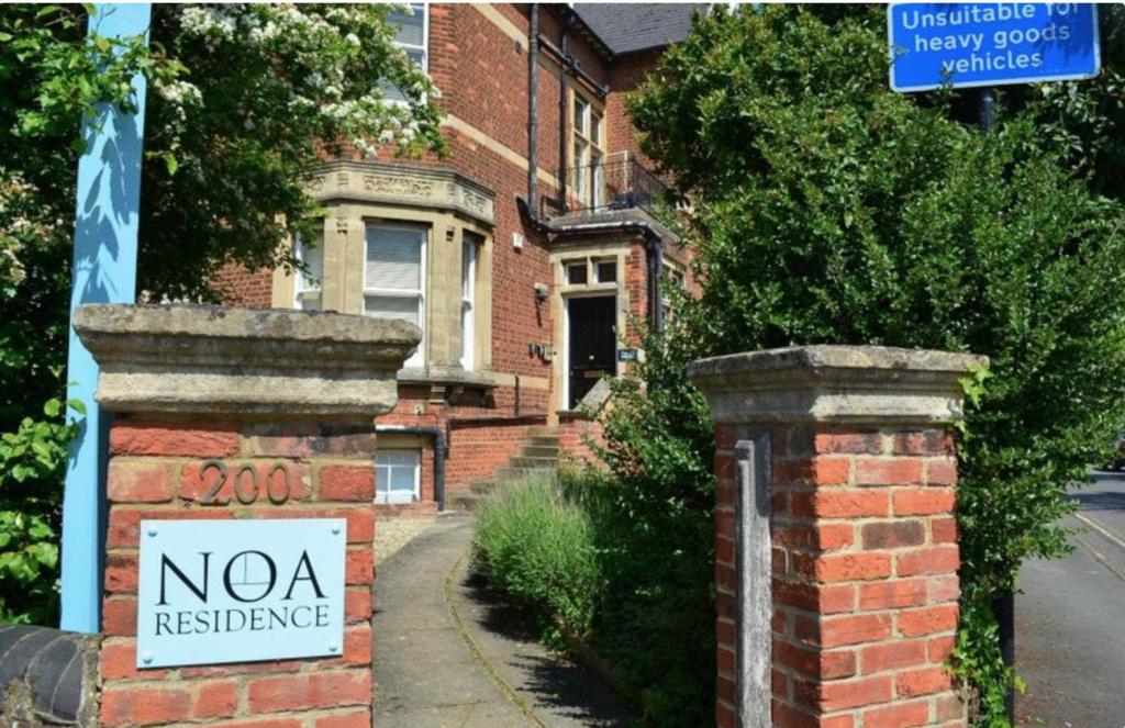 una señal de residencia nova frente a una casa de ladrillo en Noa Residence, en Oxford