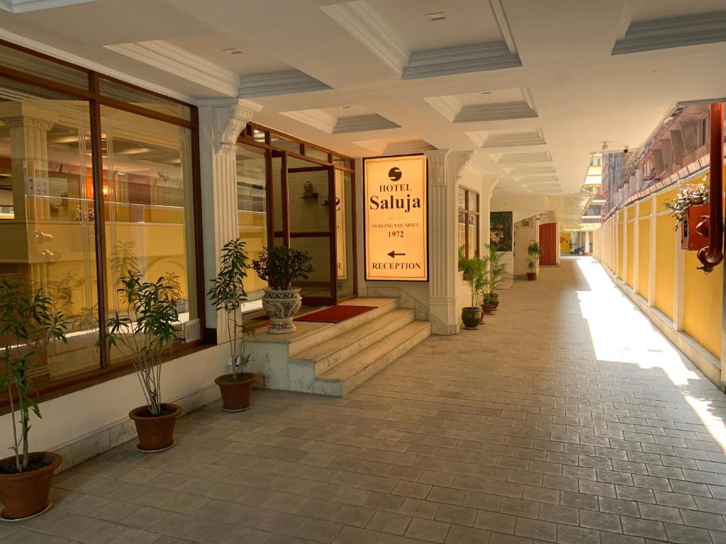 西里古里的住宿－Hotel Saluja，建筑的走廊上,有盆栽植物