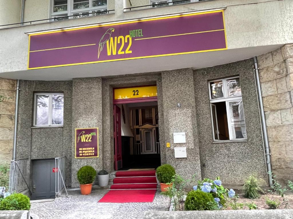 un edificio con un cartello viola sulla parte anteriore di W22 Hotel am Kurfürstendamm a Berlino
