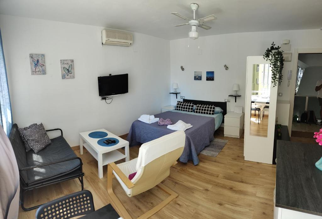 mały salon z łóżkiem i kanapą w obiekcie Solaz-Andaluz City Center Apartment BY NAMASTE ELITE w mieście Torremolinos