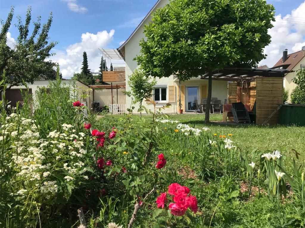 un jardín frente a una casa con flores en BergBlick am See en Friedrichshafen