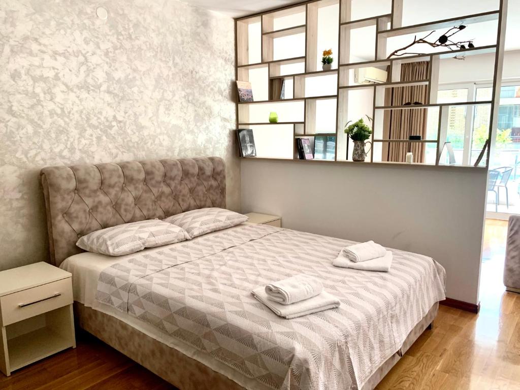 ein Schlafzimmer mit einem Bett mit zwei Handtüchern darauf in der Unterkunft Holiday apartments Petrovac in Petrovac na Moru