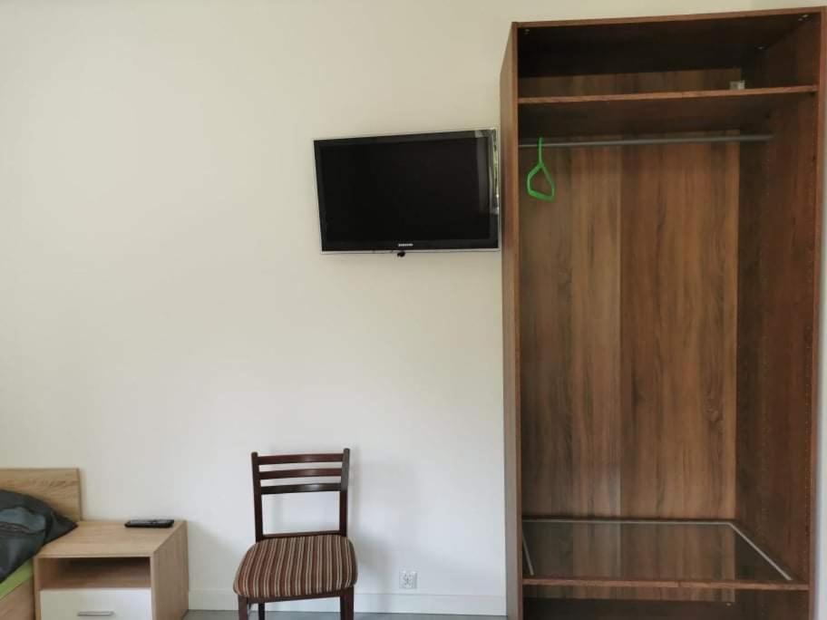 a room with a chair and a tv on a wall at Reda apartments in Lublin