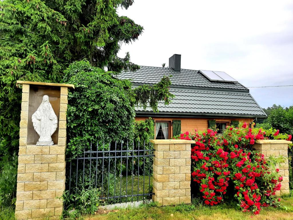 a fence in front of a house with flowers at Kosiedlisko in Kraśnik