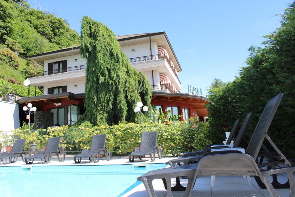 a swimming pool with chairs and a building at Lo Scoiattolo in Massino Visconti