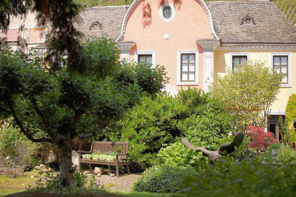 a bench in a garden in front of a house at Villa Marlene in Treis-Karden