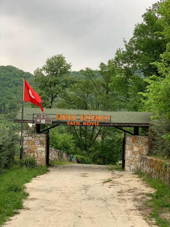 eine Brücke mit einer roten Flagge auf einer unbefestigten Straße in der Unterkunft Saklı Cennet Esadiye in Esadiye