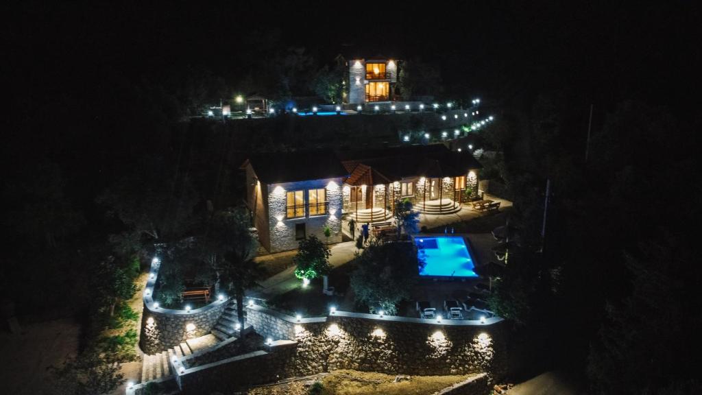 - une vue aérienne sur une maison avec une piscine la nuit dans l'établissement Rustic Villas Barlovic, à Ulcinj
