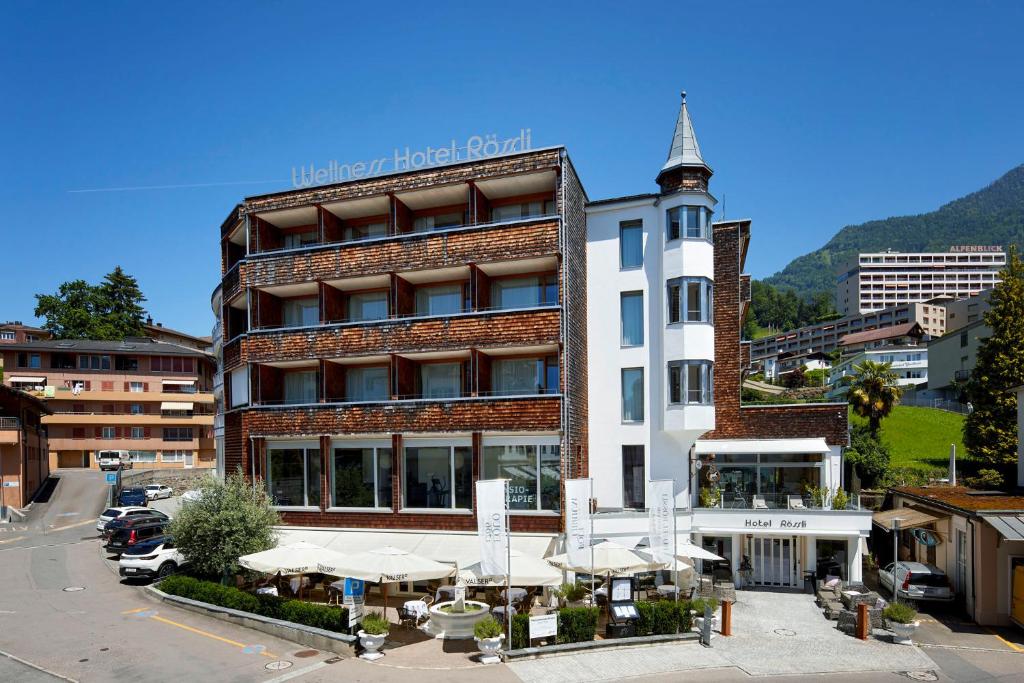 a hotel building with a clock tower in a city at Hotel Rössli Gourmet & Spa in Weggis