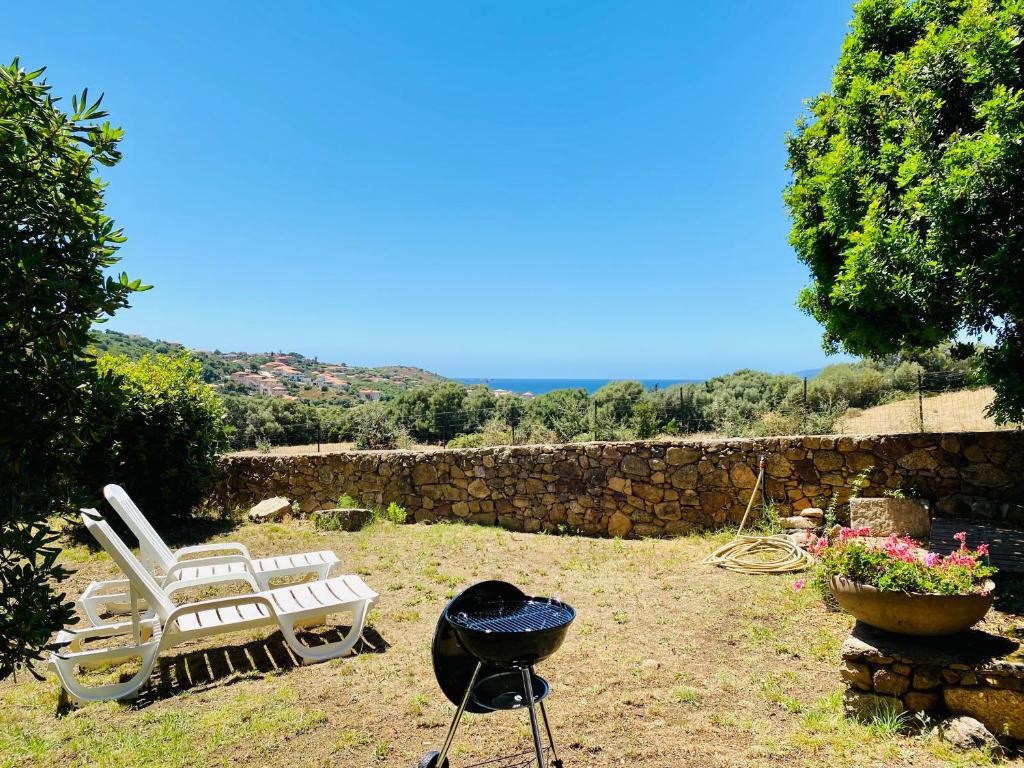 - un barbecue, 2 chaises et un barbecue dans la cour dans l'établissement Résidence Marie Diane - Laurier des Bois, à Propriano