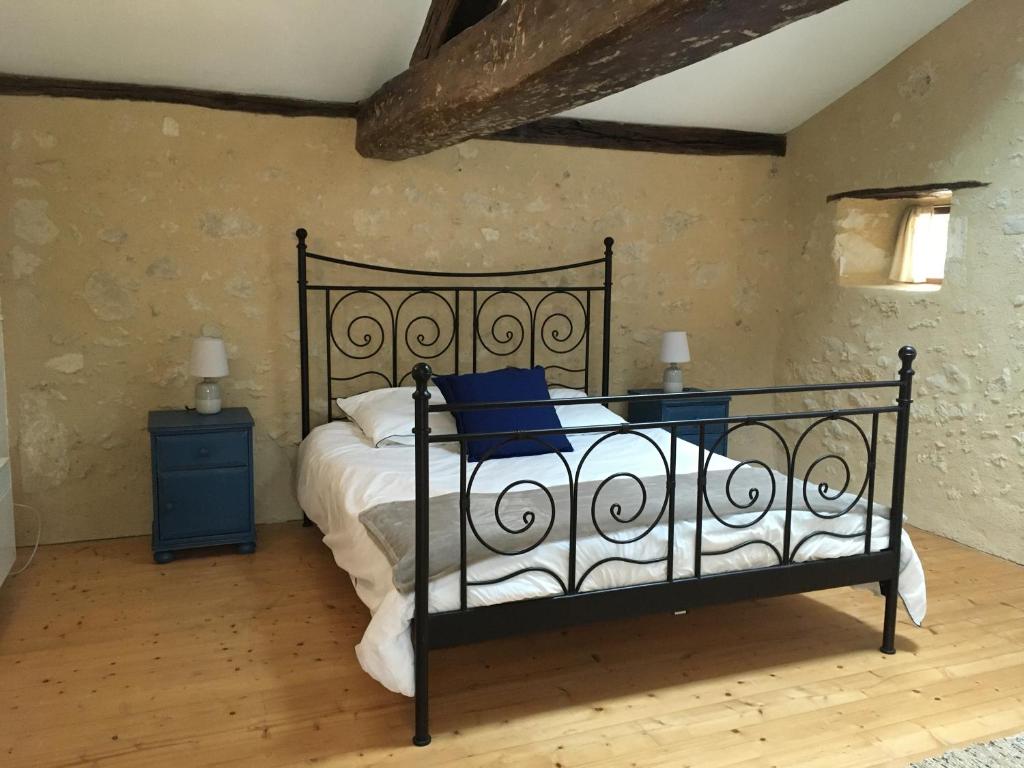 a bedroom with a black bed and a blue nightstand at L&#39;Olivier in Puisseguin