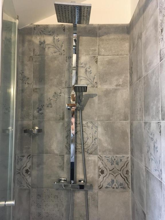 a shower with a glass door in a bathroom at L&#39;Olivier in Puisseguin