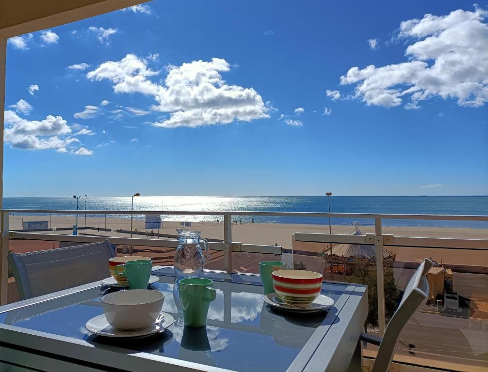 d'une table avec vue sur la plage depuis un balcon. dans l'établissement Appartement T2, 2 a 4 Personnes avec une Vue sur Mer 4TL25, à Narbonne-Plage