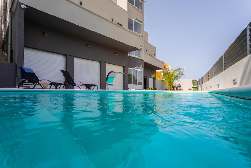 a swimming pool with chairs next to a building at Atena Zaton 2 in Nin