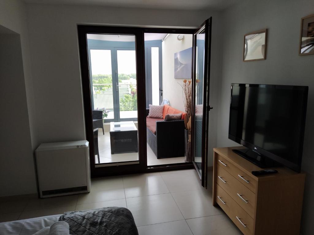 Televízia a/alebo spoločenská miestnosť v ubytovaní LIDO Apartamenty