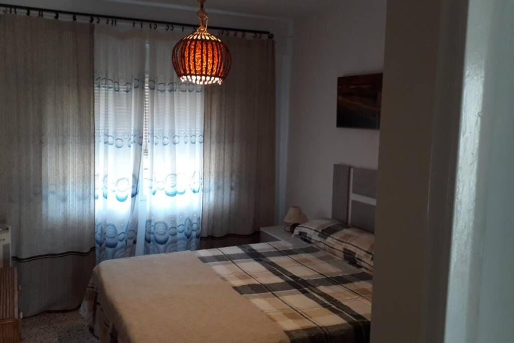 1 dormitorio con cama y lámpara de araña en Campello Alicante Playa en El Campello