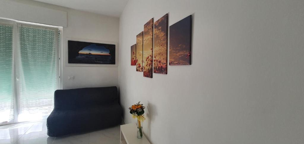 een woonkamer met een blauwe stoel en foto's aan de muur bij La Dimora di Maja in Pescara