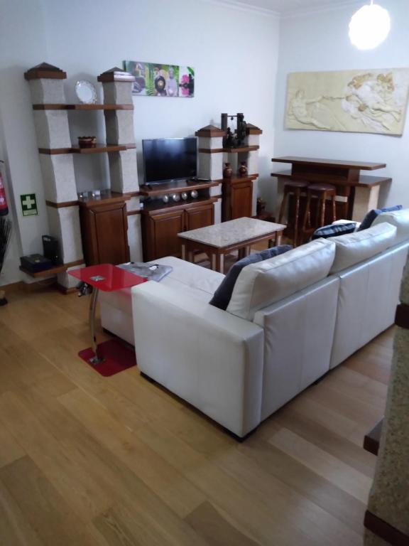 ein Wohnzimmer mit einem weißen Sofa und einem Tisch in der Unterkunft Alto Aguieira in Viseu