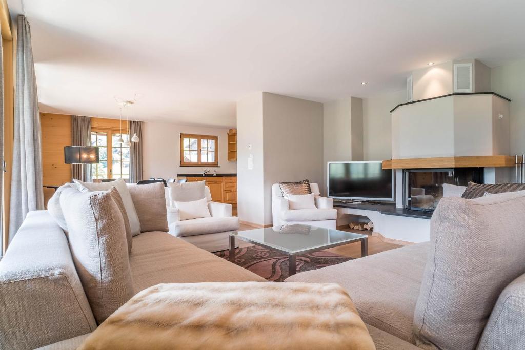 a living room with a couch and a tv at Apartment Bränderli - GRIWA RENT AG in Grindelwald