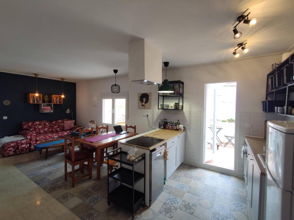 a kitchen and living room with a table and a couch at Casa Escalada Palma de Gandia in Palma de Gandía