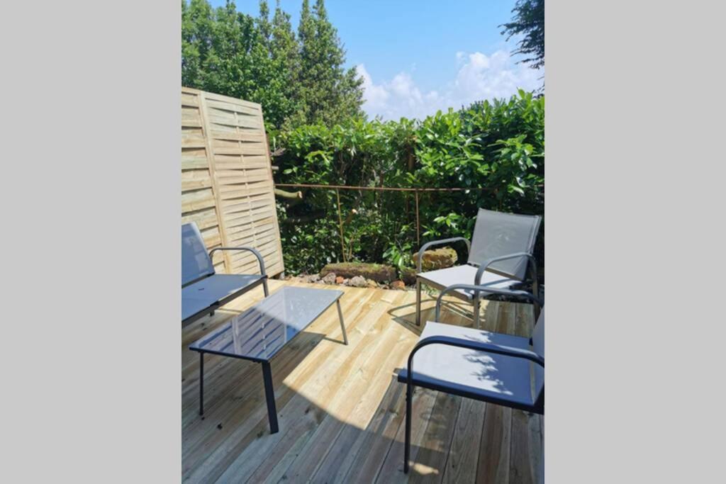une terrasse avec deux chaises, une table et des chaises dans l'établissement Le 3 de coeur avec terrasse, à Honfleur