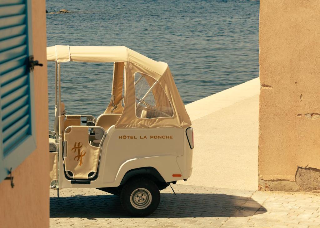 a small golf cart parked next to the water at Hotel la Ponche in Saint-Tropez