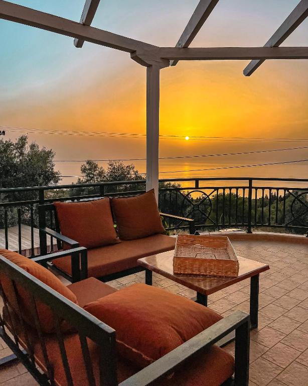 a patio with a couch and a table and a sunset at Villa Anna in Athani
