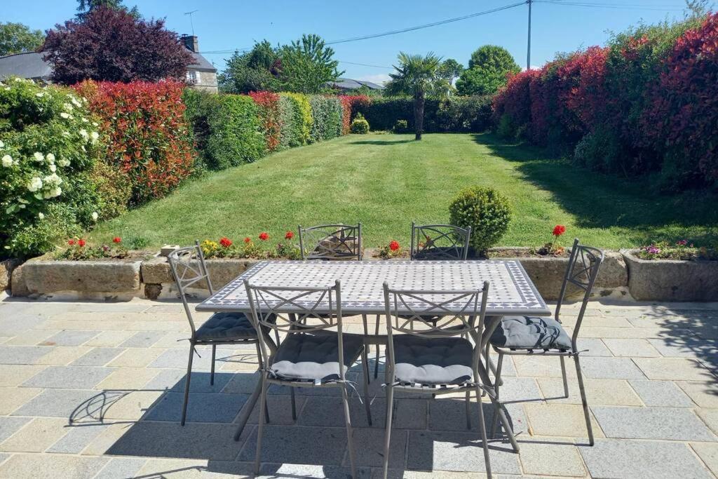 a table and chairs sitting on a patio at LA MAISON BLEUE in Saint-Sauveur-des-Landes