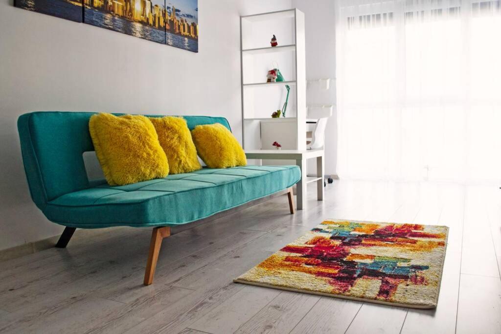 um sofá verde com almofadas amarelas numa sala de estar em Dream Apartment+parcare gratuita em Oradea