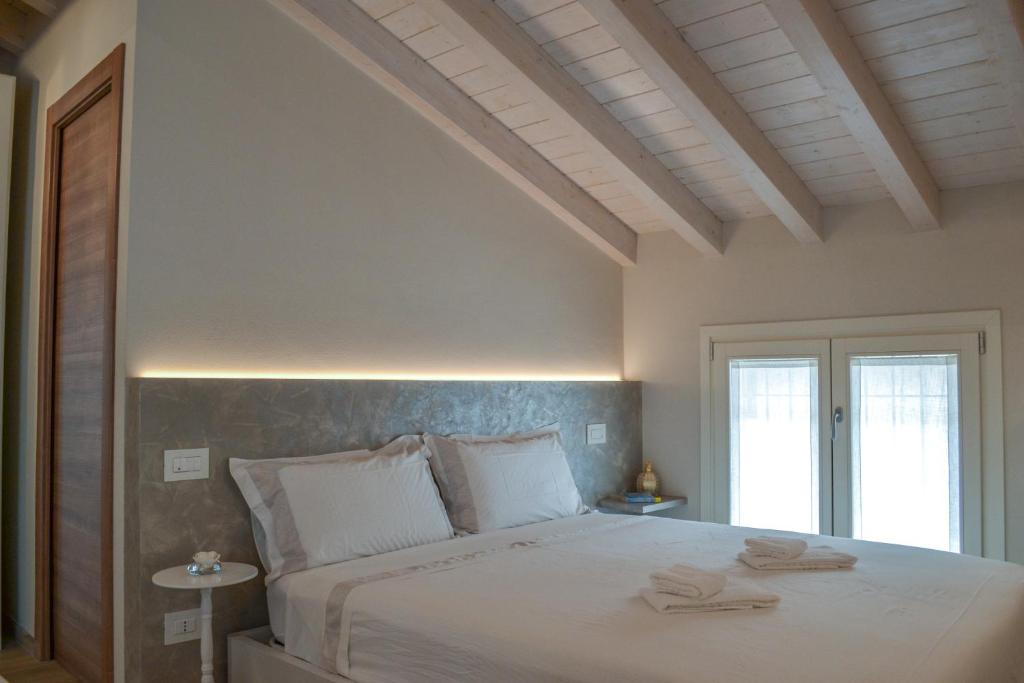 1 dormitorio con 1 cama grande y 2 toallas. en Garda Lake Maison d'Isabella, en Lonato