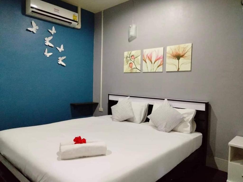 Un dormitorio con una cama blanca con pájaros en la pared en Krabi Nemo House, en Ao Nang Beach