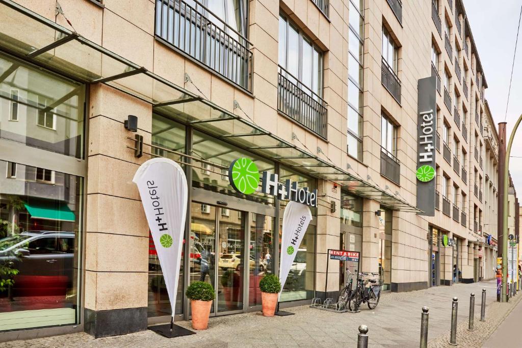 un magasin à l'avant d'un bâtiment avec de grandes fenêtres dans l'établissement H+ Hotel Berlin Mitte, à Berlin