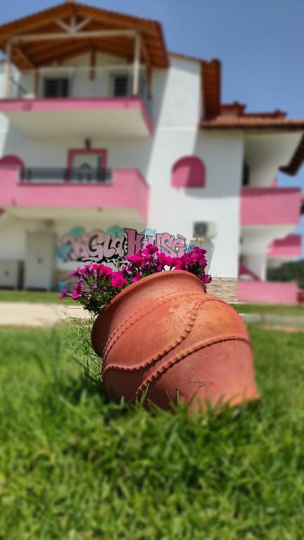 a flower pot sitting in the grass in front of a house at Vigla House in Sykia Chalkidikis