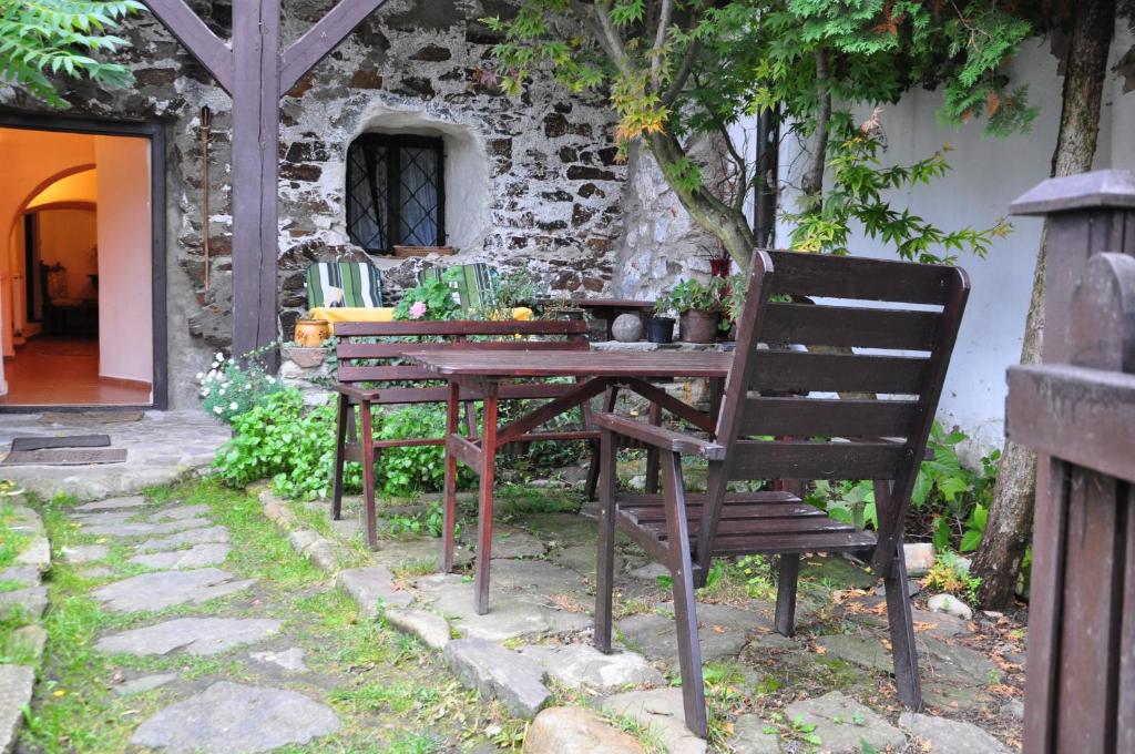 a wooden table and two chairs sitting next to a building at Guest House Olšakovský in Český Krumlov