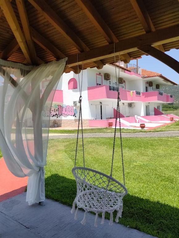 a swing on a patio with a house at Vigla House in Sykia Chalkidikis