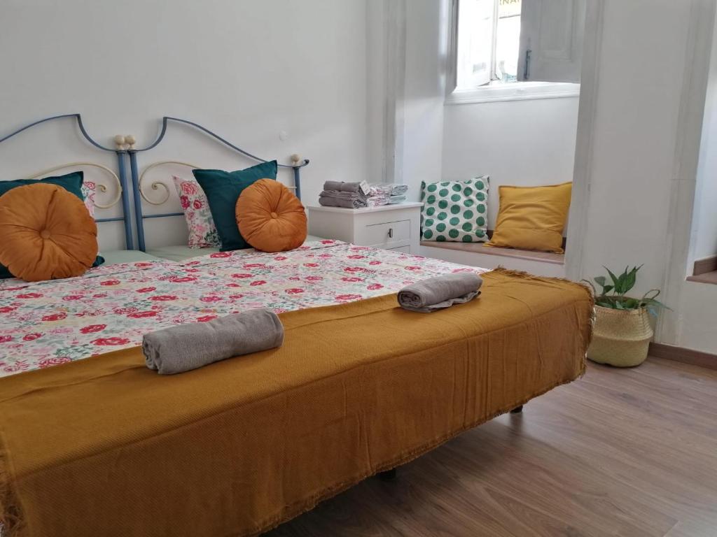 ein Schlafzimmer mit einem großen Bett mit orangefarbenen Kissen in der Unterkunft Dream Days Guesthouse in Faro