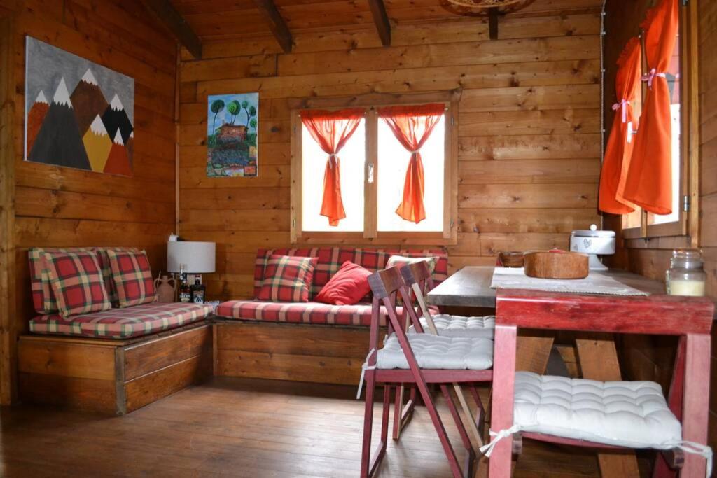 a room with benches and a table in a cabin at Intry Etna Chalet in Pedara