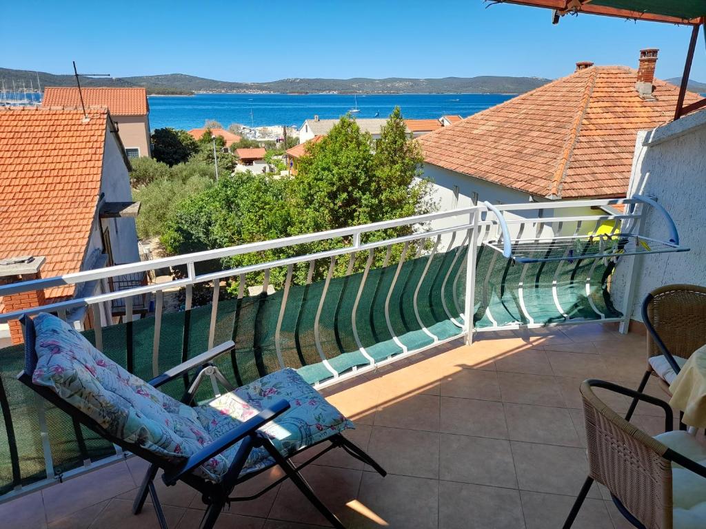 einen Balkon mit Stühlen und Blick auf das Wasser in der Unterkunft Apartment Gotovina Biograd na Moru in Biograd na Moru