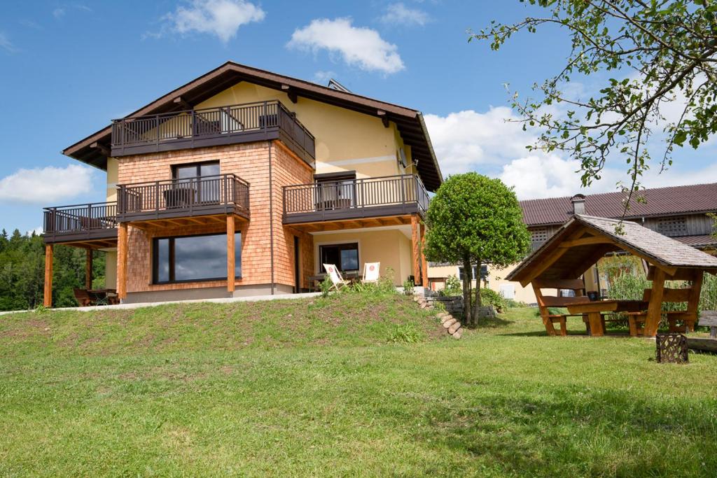 ein Backsteinhaus mit einem Balkon und einem Hof in der Unterkunft Ferienwohnungen Schöbringer in Weyregg