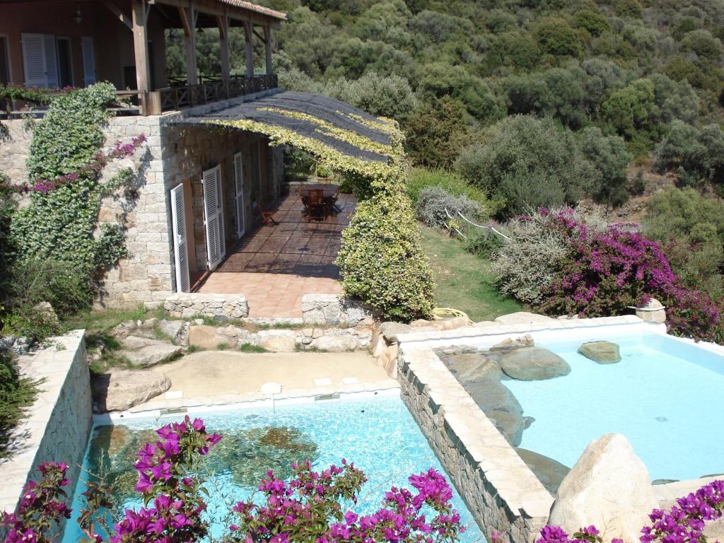 una vista exterior de una casa con piscina y flores en Villas Valinco Capicciolo vue-proche mer-piscines, en Olmeto