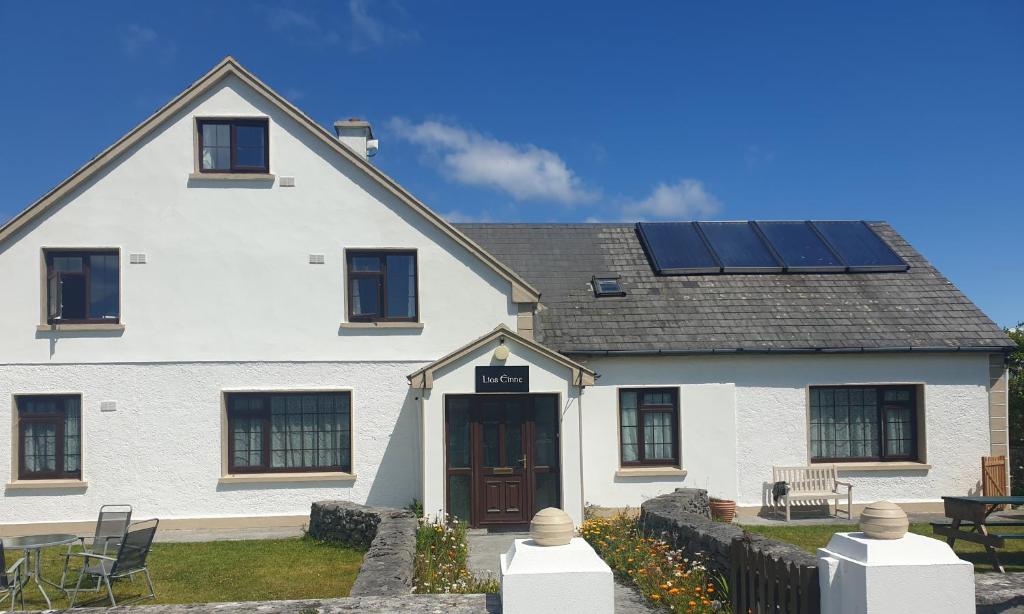 a white house with solar panels on the roof at Lios Éinne House Accommodation in Inisheer
