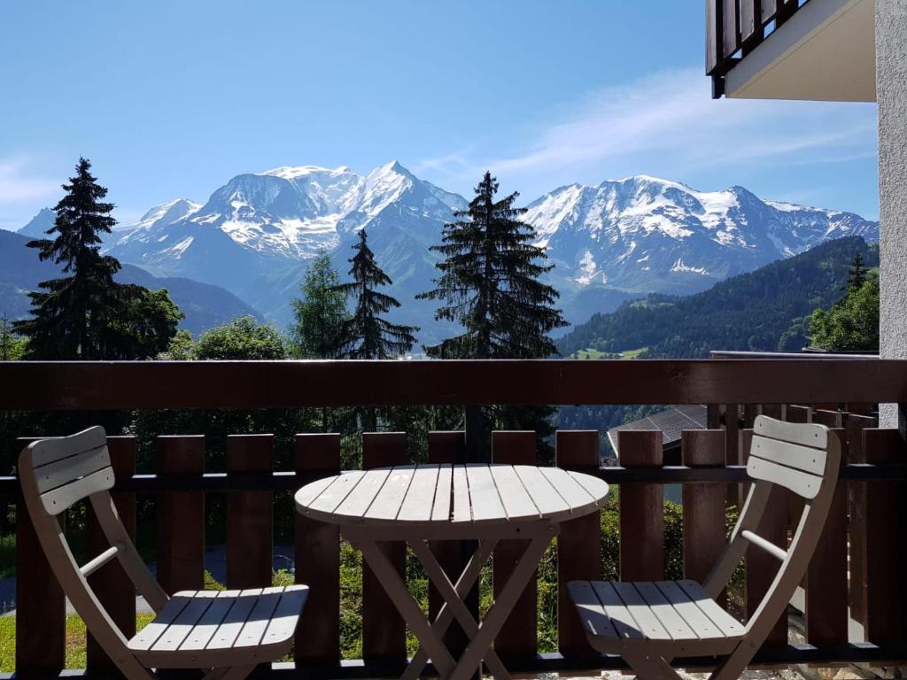 stół i krzesła na balkonie z widokiem na góry w obiekcie Appartement Saint Gervais les Bains vue imprenable Mont Blanc w mieście Saint-Gervais-les-Bains