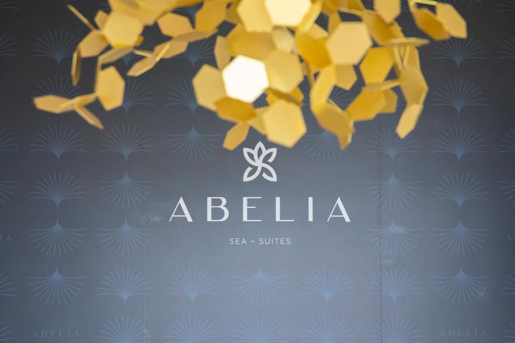 Abelia Sea Suites في تشفالو: لافتة عليها زهور صفراء على خلفية زرقاء