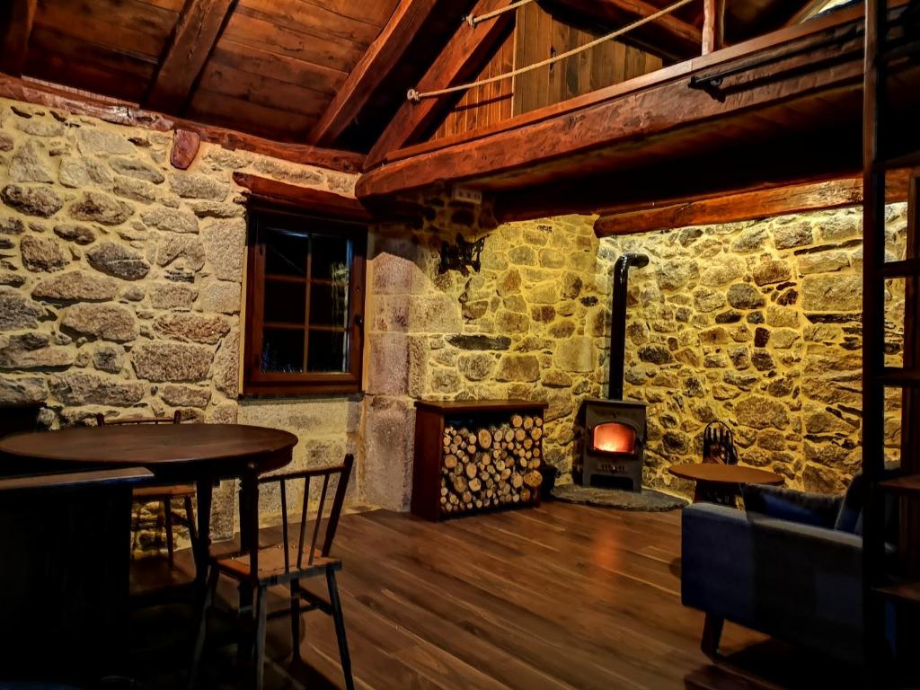 Habitación con mesa y estufa de leña. en El Cuarto en Suarbol