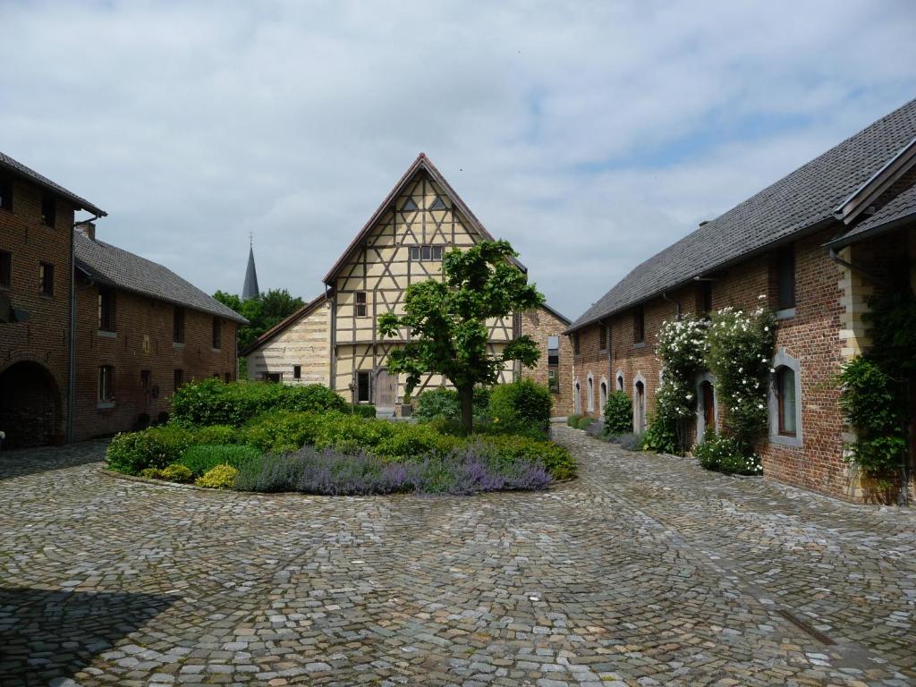 una strada di ciottoli di fronte ad alcuni edifici di Hof van Eggertingen nr. 8 a Riemst